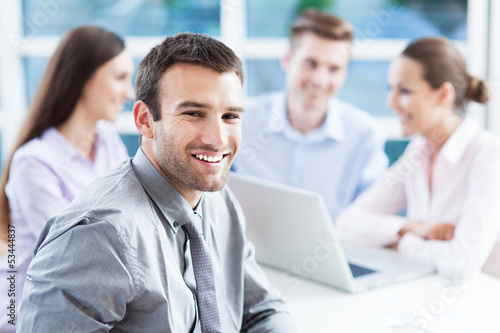 Businessman with coworkers in background