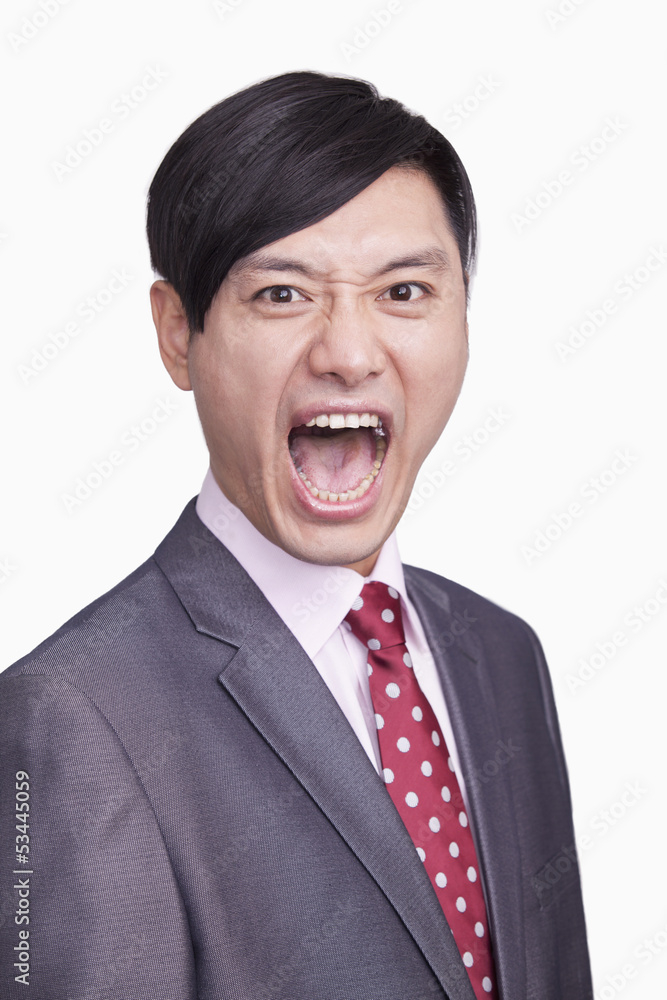 Portrait of angry young businessman, studio shot Portrait of angry young businessman, studio shot