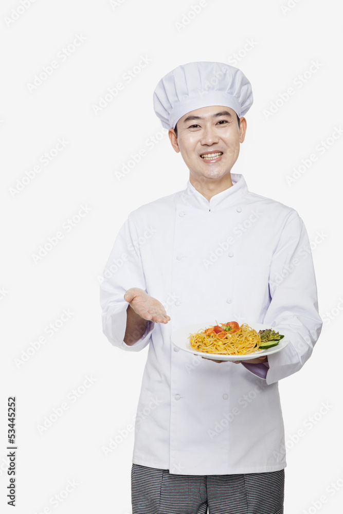 Chef showing prepared food, studio shot Chef showing prepared food, studio shot