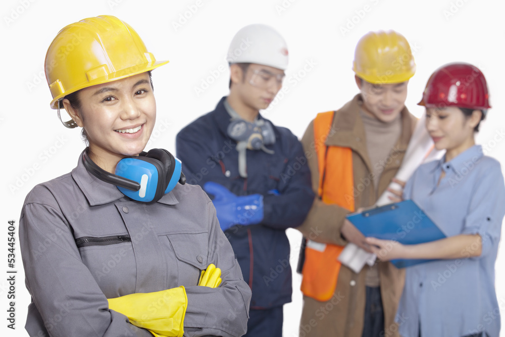 Four construction workers against white background, focus in foreground Four construction workers against white background, focus in foreground