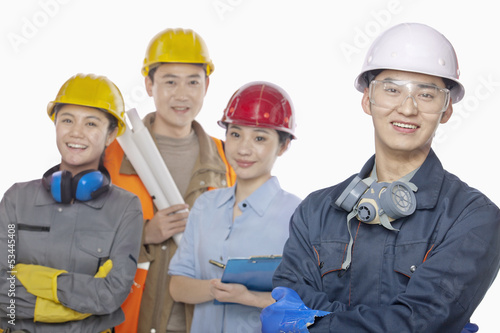 Four construction workers against white background, focus in foreground