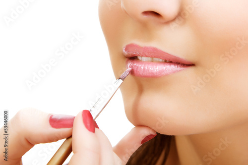 esthetician apply lipstick on female lips closeup