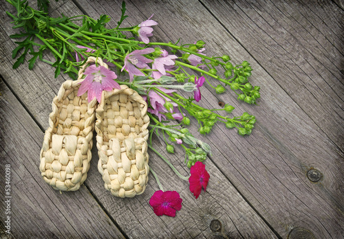 Rural still life with mallow and sandals made of bark photo