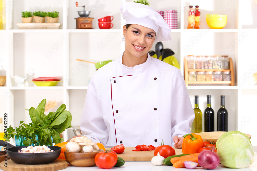Young woman chef cooking in kitchen Young woman chef cooking in kitchen