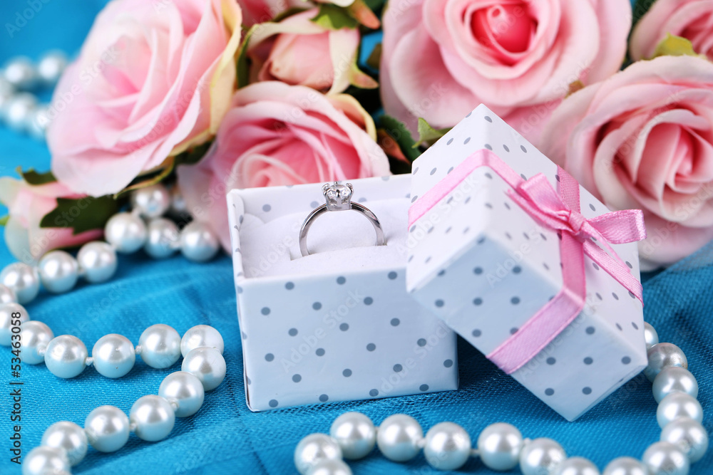 Rose and engagement ring on blue cloth Rose and engagement ring on blue cloth