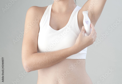 Woman trimming her armpit with electric trimmer