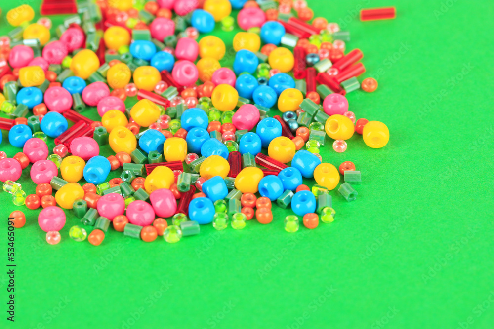 Fototapeta premium Different colorful beads on green background