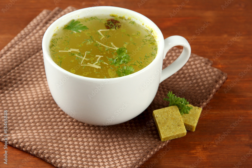 Cup of soup with bouillon cubes on wooden background Cup of soup with bouillon cubes on wooden background