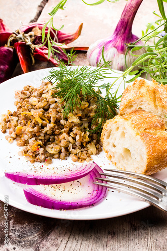 Russian cuisine. Buckwheat porridge, bresd, red onion  and herbs photo