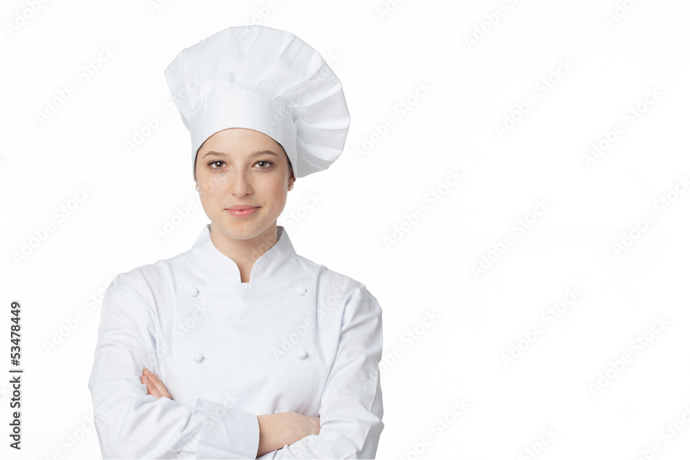 A young, female chef in a traditional hat and coat.. A young, female chef in a traditional hat and coat..
