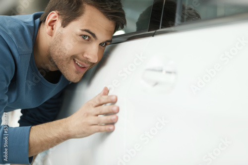 The final check. Handsome young men examining a car at the deale photo