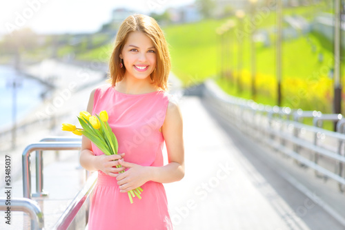 Smiling girl with yellow tulips photo