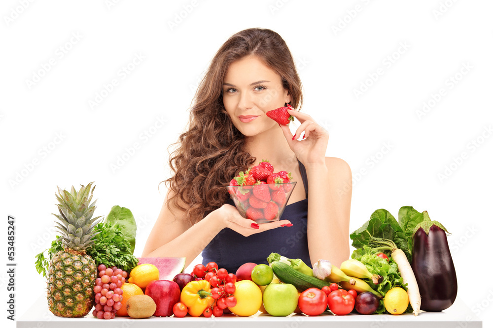 Young female holding a bowl of strawberries and posing behind a Young female holding a bowl of strawberries and posing behind a