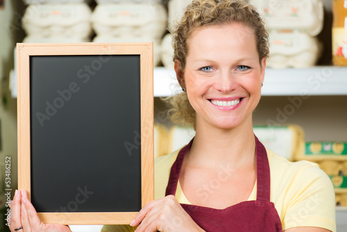 Fotografi salesclerk with sign-board in front of egg cartons