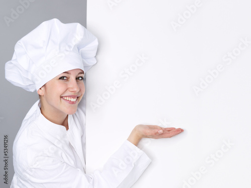 Female cook shows white blackboard with copyspace photo