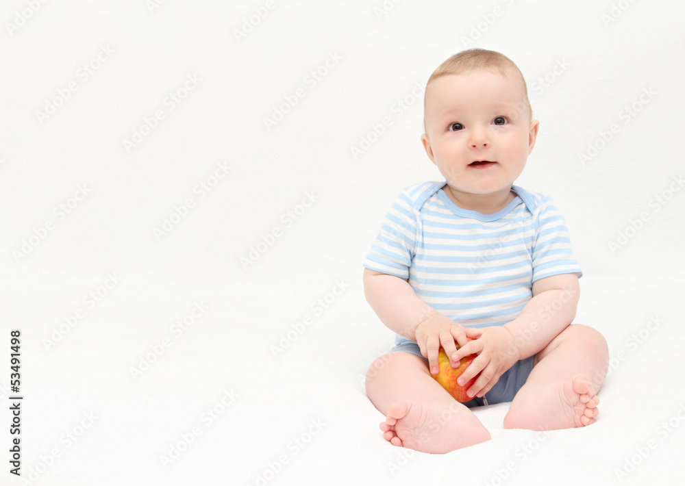 beautiful happy baby boy sitting on white bed with apple beautiful happy baby boy sitting on white bed with apple