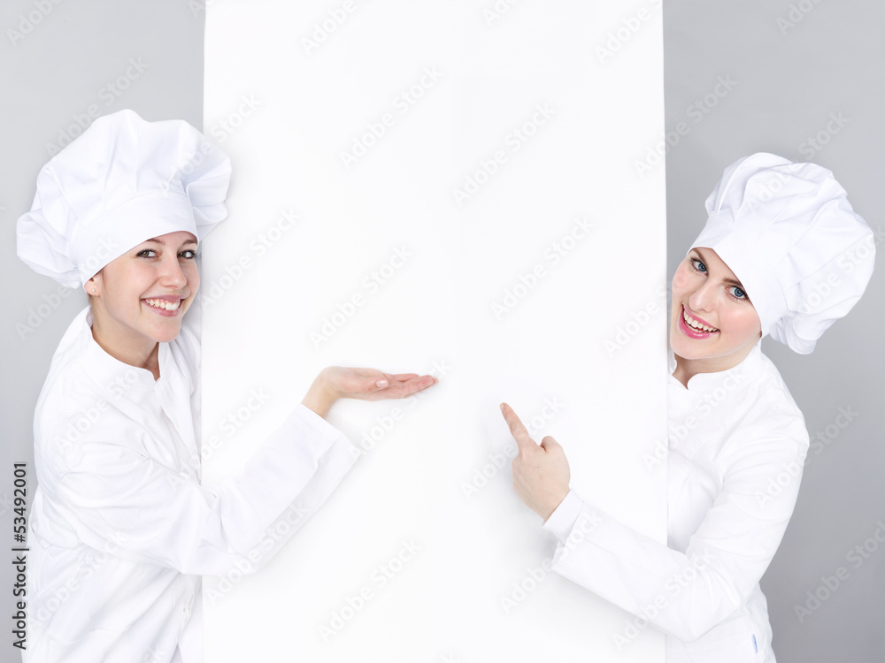 Female cooks show white blackboard with copyspace Female cooks show white blackboard with copyspace