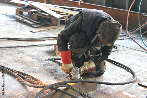 Worker is cutting metal by grinder