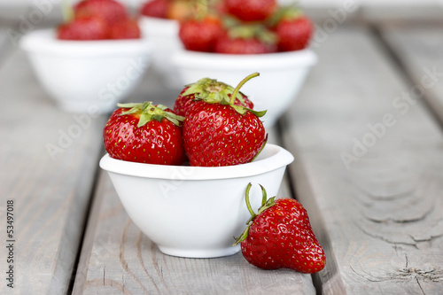 Fresh ripe strawberries in white ceramic bowl