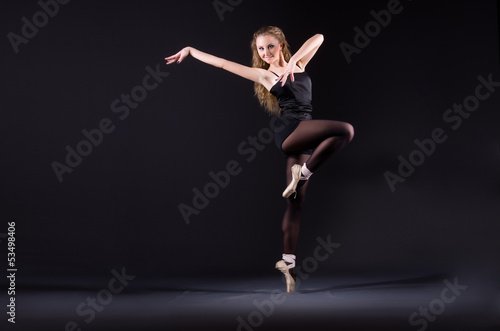 Ballerina dancing in the dark studio