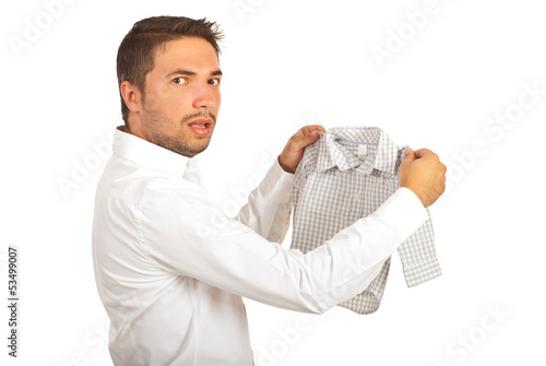 Shocked man holding shrunk shirt