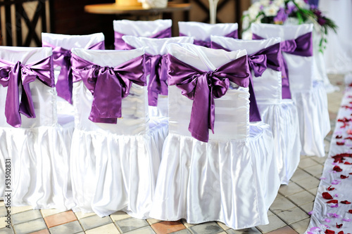 The chairs are decorated with purple bows