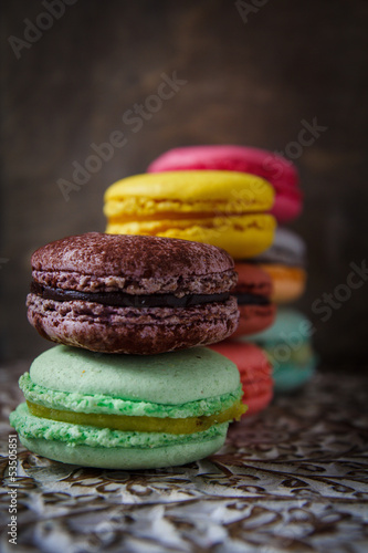 Colorful french macaroons on dark wooden background