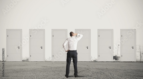 Businessman choosing the right door photo