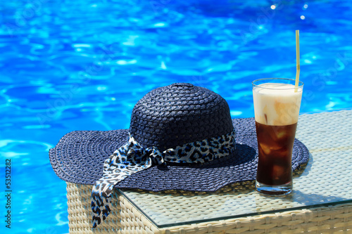 Ice coffee Fredo against blue clear water of the swimming pool photo