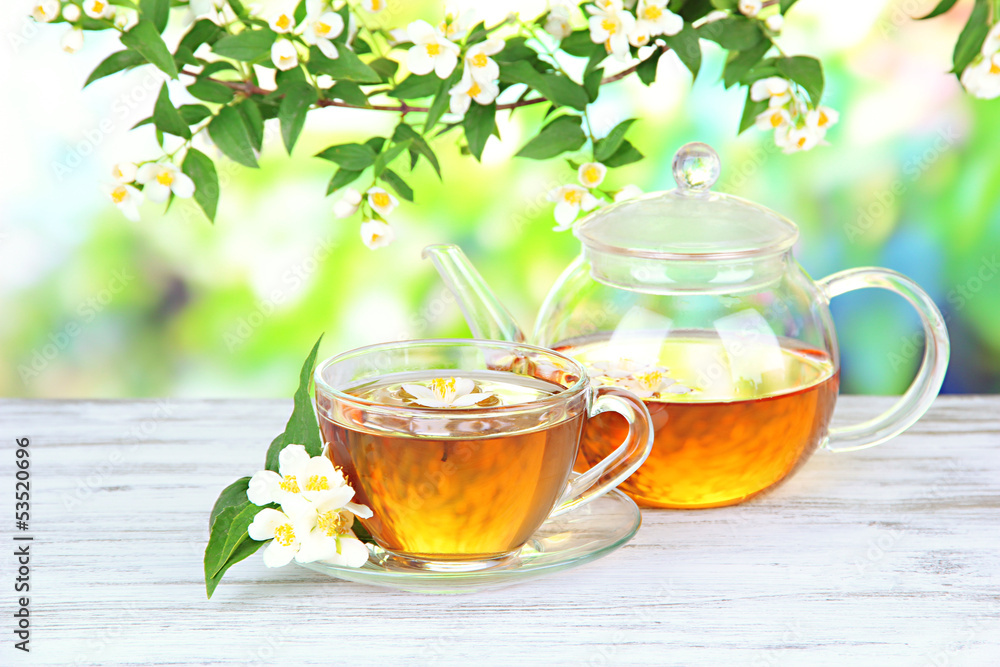 Cup of tea with jasmine, on wooden table, on bright background Cup of tea with jasmine, on wooden table, on bright background