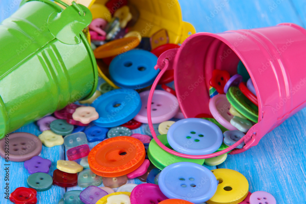 Colorful buttons strewn from buckets close-up Colorful buttons strewn from buckets close-up