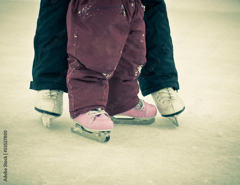 Fototapeta premium Child and parent feet on skates