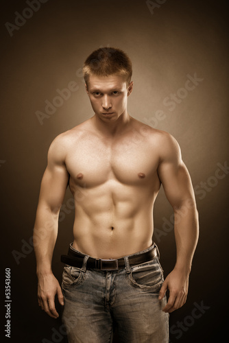Healthy muscular young man posing in studio