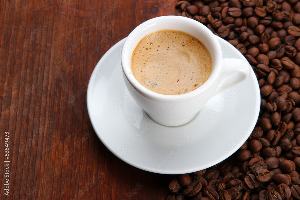 Cup of coffee with coffee beans on wooden background Cup of coffee with coffee beans on wooden background