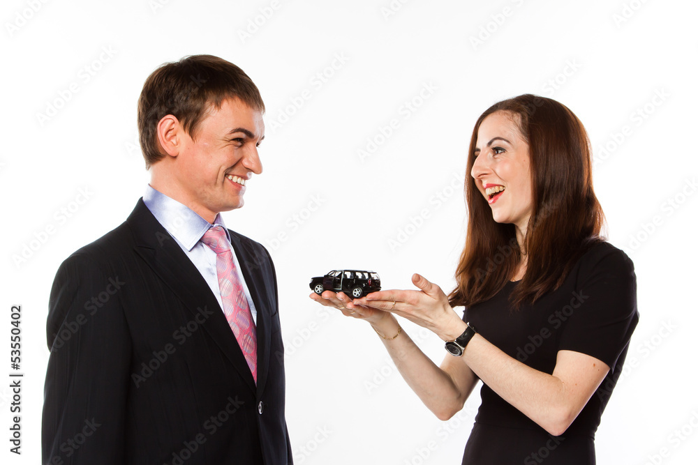 young man and woman are holding a toy car young man and woman are holding a toy car