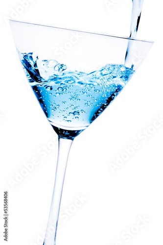 filling a glass with blue cocktail tilted and bubbles
