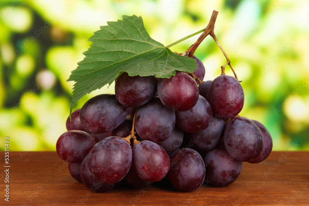 Ripe delicious grapes on table on bright background Ripe delicious grapes on table on bright background