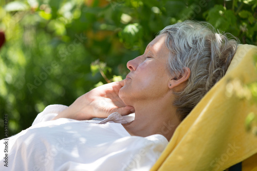 Aged woman sleeping on lounger