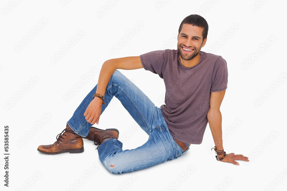 Smiling man sitting on floor