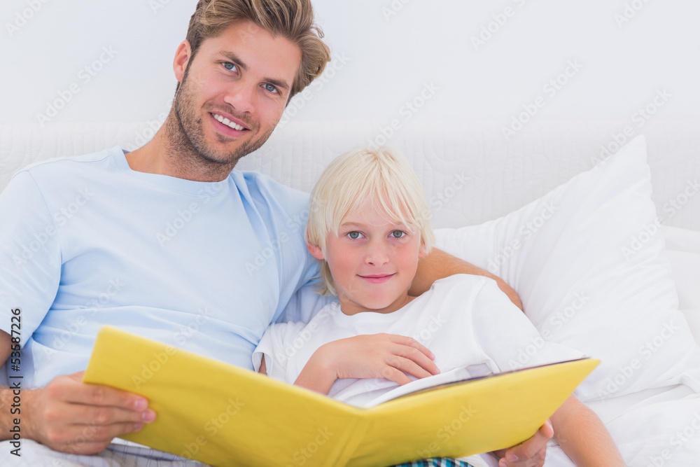 Handsome father reading a story to his son Handsome father reading a story to his son
