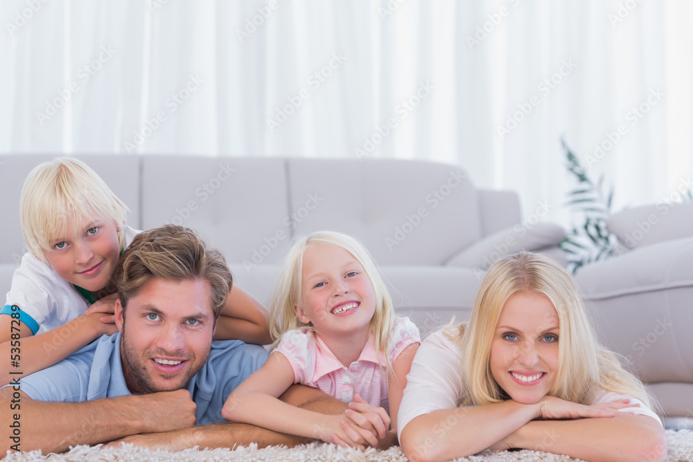 Smiling family lying on the carpet Smiling family lying on the carpet