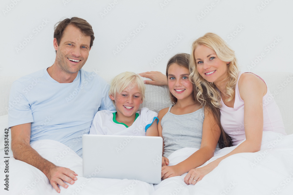 Smiling family using a laptop together Smiling family using a laptop together