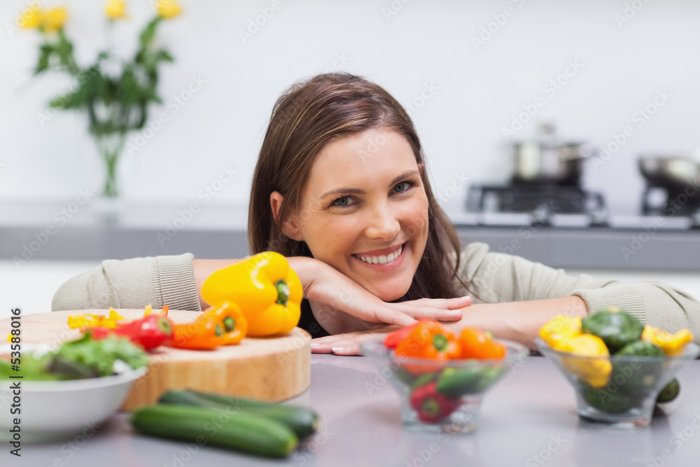 Cheerful woman leaning on the counter of her kitchen Cheerful woman leaning on the counter of her kitchen