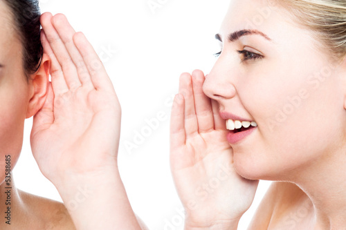 Teenage girl whispering a secret