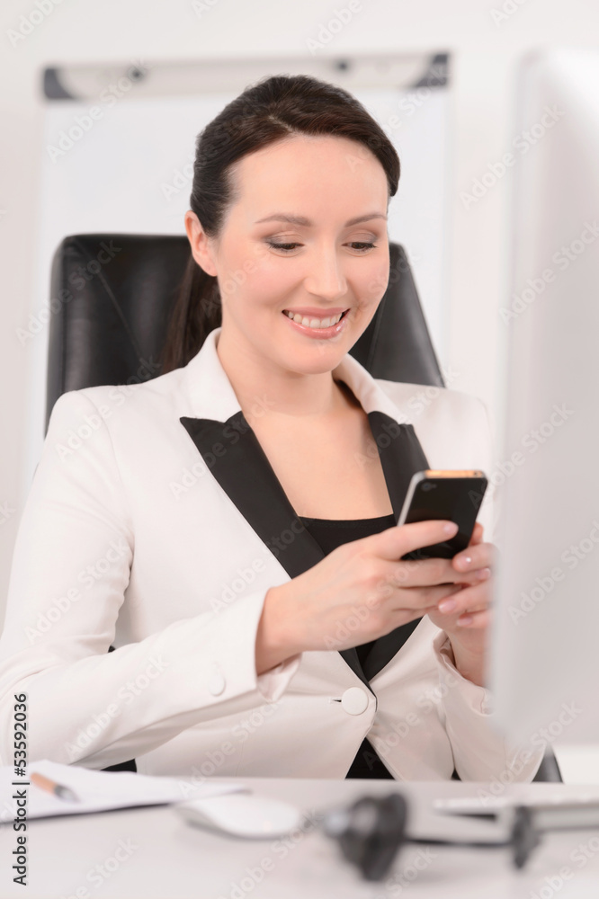 Dialing a number. Beautiful middle-aged businesswoman sitting at Dialing a number. Beautiful middle-aged businesswoman sitting at