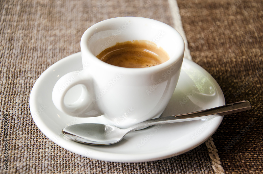 Cup of espresso over brown tablecloth Cup of espresso over brown tablecloth