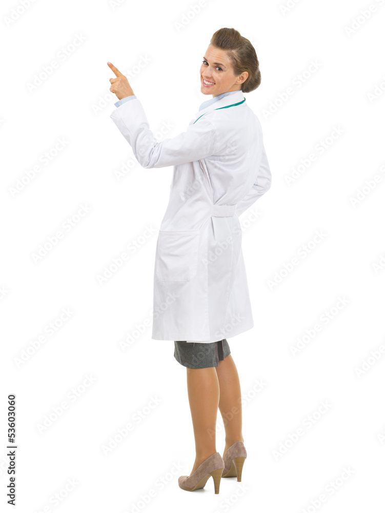 Full length portrait of doctor woman pointing up on copy space Full length portrait of doctor woman pointing up on copy space