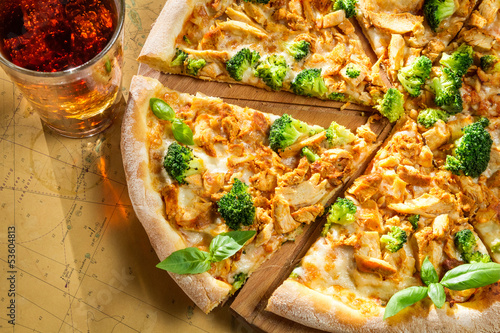 Fresh pizza made of broccoli, chicken and basil