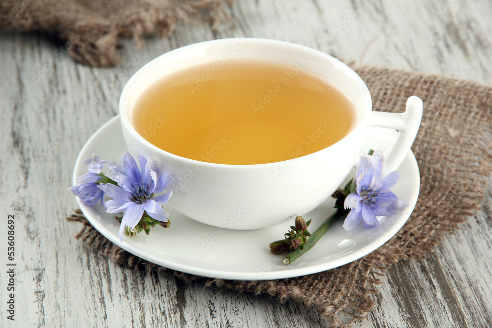 Cup of tea with chicory, on wooden background Cup of tea with chicory, on wooden background