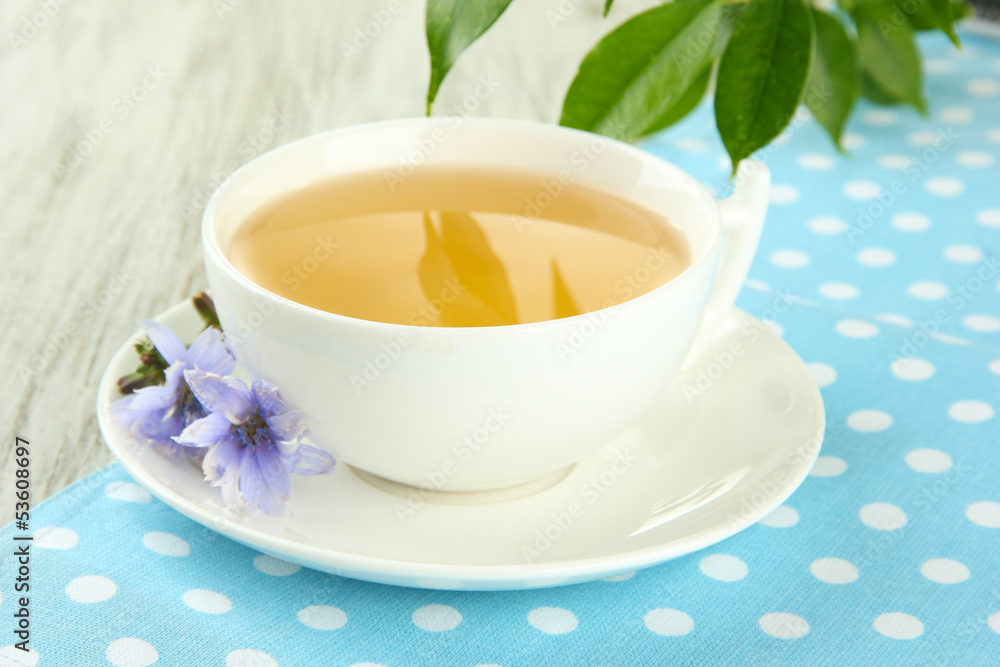 Cup of tea with chicory, on wooden background Cup of tea with chicory, on wooden background